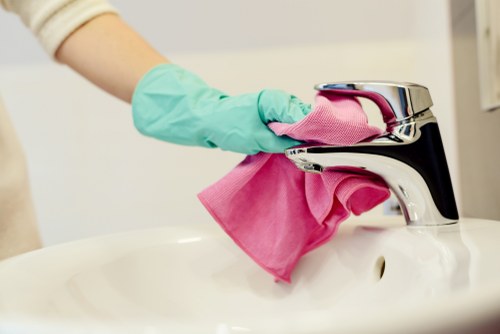 Professional oven cleaner wearing PPE while protecting kitchen surfaces