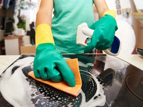 Cleaner maintaining a busy office kitchen and communal area